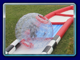 Criss Cross Collision is an inflatable human hamster ball course recommended for all ages and events. 100ft long and has nearly 250ft of racing lane action.  The game is filled with loads of obstacles and varied terrains. For an added splash, it also has four water traps that can be filled with a couple of inches of water.